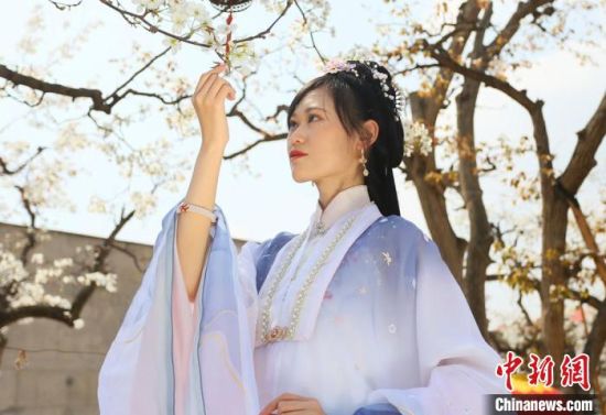 圖為蘭州青年身穿漢服在百年梨園賞景?！「哒?攝