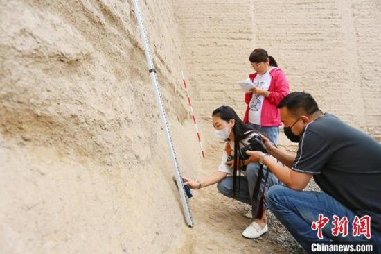 科技保護讓長城價值的真實性和完整性得到有效延續(xù)和傳承。圖為文物工作者正在測量關城的相關數(shù)據(jù)?！「哒?攝