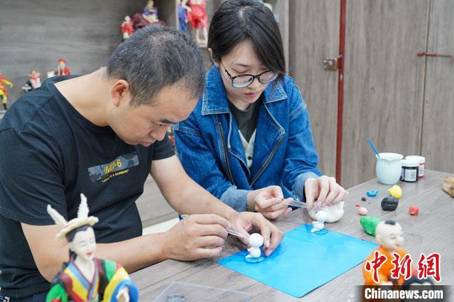 <a target='_blank'  data-cke-saved- >中新社</a>記者(右)現(xiàn)場體驗(yàn)面塑制作過程?！￡悹帍?qiáng) 攝