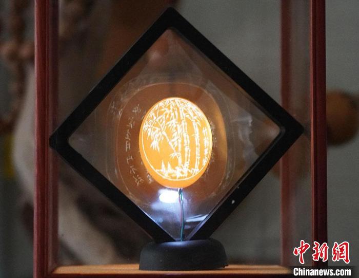 圖為吳義澤新包裝給蛋雕呈現(xiàn)立體感?！【琶赖ぴ?攝