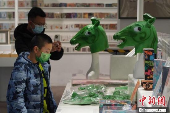圖為“神馬來(lái)了”銅奔馬頭套吸引參觀者駐足?！【琶赖┰?攝