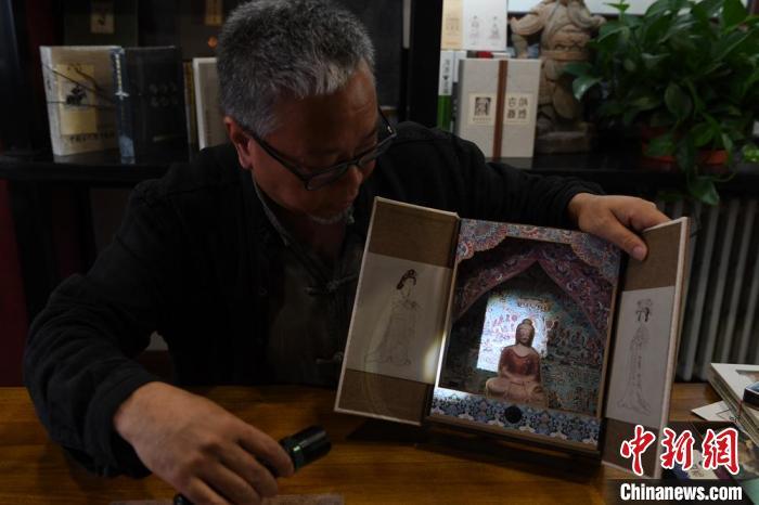 圖為讀者出版集團讀者晉林工作室獨立出品人徐晉林，展示互動性強的敦煌題材手工書。(資料圖) 楊艷敏 攝