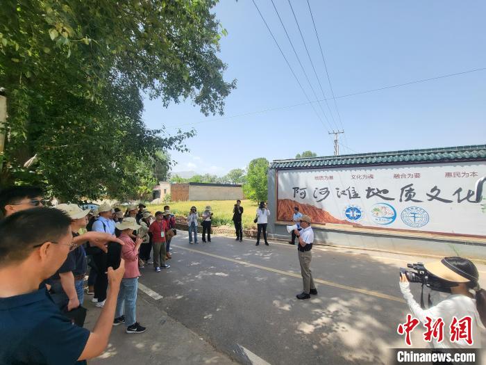 圖為中國(guó)地質(zhì)大學(xué)(北京)教授張緒教介紹村落情況。　胡友軍 攝