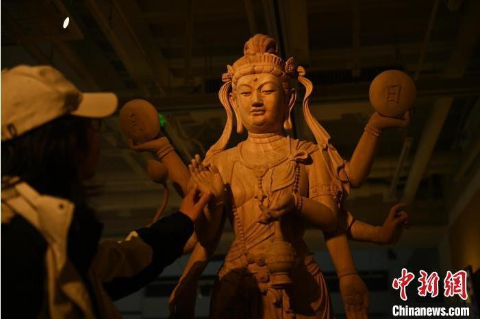 圖為季茂杰觀察自己創(chuàng)作的敦煌木雕。李亞龍 攝</p>
<p>