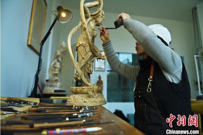 圖為季茂杰進行敦煌元素的木雕創(chuàng)作。李亞龍 攝</p>
<p>