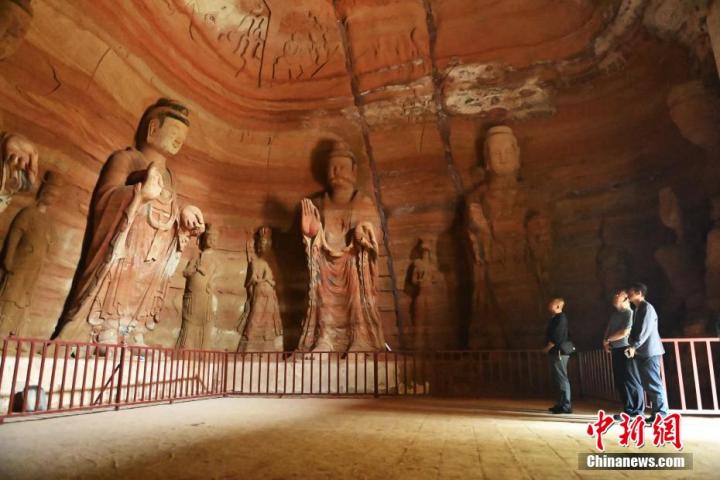 7月15日，游人參觀甘肅省平?jīng)鍪袥艽h百里石窟長(zhǎng)廊中的南石窟寺1號(hào)窟。百里石窟長(zhǎng)廊位于涇川縣境內(nèi)，由512個(gè)石窟、5眼窟中石井組成，現(xiàn)存王母宮石窟、鳳凰山石窟、南石窟寺、丈八寺石窟、羅漢洞石窟、太山寺石窟等規(guī)模較大的石窟群，還有數(shù)量眾多的小石窟群。南石窟寺開鑿于北魏永平三年，其中1號(hào)窟屬于大型七佛窟，七佛高達(dá)6米。中新社記者 李亞龍 攝