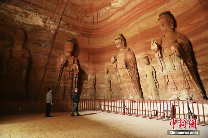 7月15日，游人參觀甘肅省平?jīng)鍪袥艽h百里石窟長(zhǎng)廊中的南石窟寺1號(hào)窟。百里石窟長(zhǎng)廊位于涇川縣境內(nèi)，由512個(gè)石窟、5眼窟中石井組成，現(xiàn)存王母宮石窟、鳳凰山石窟、南石窟寺、丈八寺石窟、羅漢洞石窟、太山寺石窟等規(guī)模較大的石窟群，還有數(shù)量眾多的小石窟群。南石窟寺開鑿于北魏永平三年，其中1號(hào)窟屬于大型七佛窟，七佛高達(dá)6米。中新社記者 李亞龍 攝