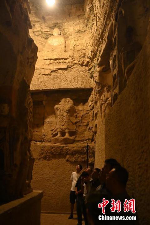 7月15日，游人參觀甘肅省平?jīng)鍪袥艽h百里石窟長(zhǎng)廊中的王母宮石窟。百里石窟長(zhǎng)廊位于涇川縣境內(nèi)，由512個(gè)石窟、5眼窟中石井組成，現(xiàn)存王母宮石窟、鳳凰山石窟、南石窟寺、丈八寺石窟、羅漢洞石窟、太山寺石窟等規(guī)模較大的石窟群，還有數(shù)量眾多的小石窟群。王母宮石窟又名千佛洞，該窟設(shè)計(jì)宏大，造像生動(dòng)，窟內(nèi)擁有造像數(shù)百尊，是較為珍貴的佛教文化遺存。中新社記者 李亞龍 攝</p>
<p>