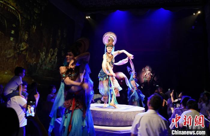 《樂(lè)動(dòng)敦煌》是全球首部洞窟式沉浸體驗(yàn)劇，利用真人與數(shù)字影像虛實(shí)交換實(shí)現(xiàn)沉浸式體驗(yàn)。圖為2023年8月28日晚，《樂(lè)動(dòng)敦煌》演出。(資料圖)中新社記者 毛建軍 攝